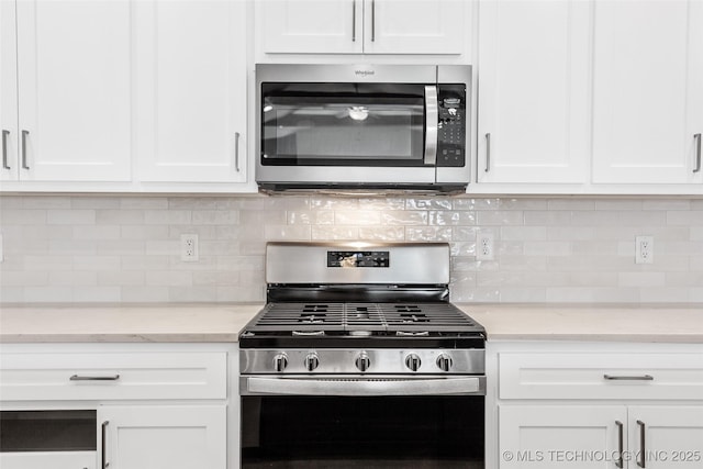 kitchen with appliances with stainless steel finishes, white cabinets, and light stone counters