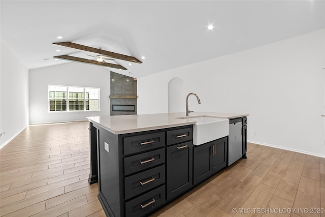 kitchen featuring sink, vaulted ceiling with beams, a center island with sink, dishwasher, and ceiling fan