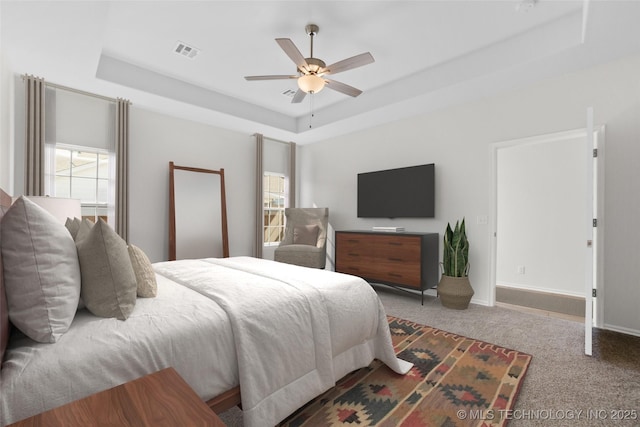 1941 W Huntsville Pl, Broken Arrow, OK 74011 - bedroom featuring a tray ceiling, multiple windows, carpet, and a ceiling fan