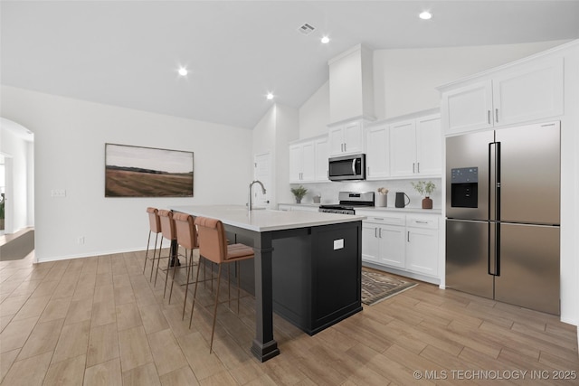 1941 W Huntsville Pl, Broken Arrow, OK 74011 - kitchen featuring stainless steel appliances, a center island with sink, light countertops, high vaulted ceiling, and white cabinets