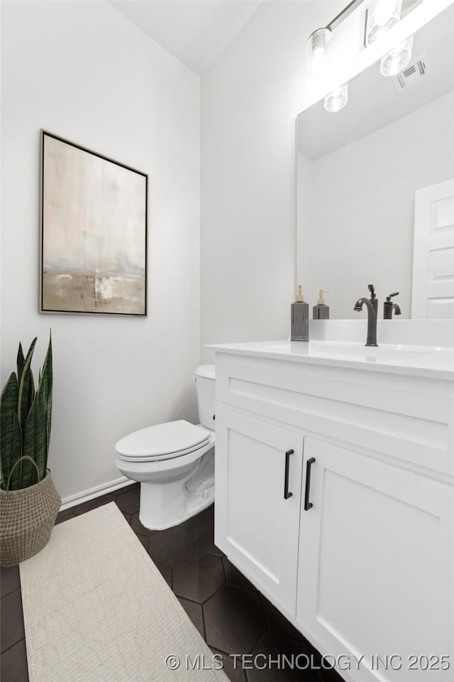 bathroom with tile patterned flooring, vanity, and toilet