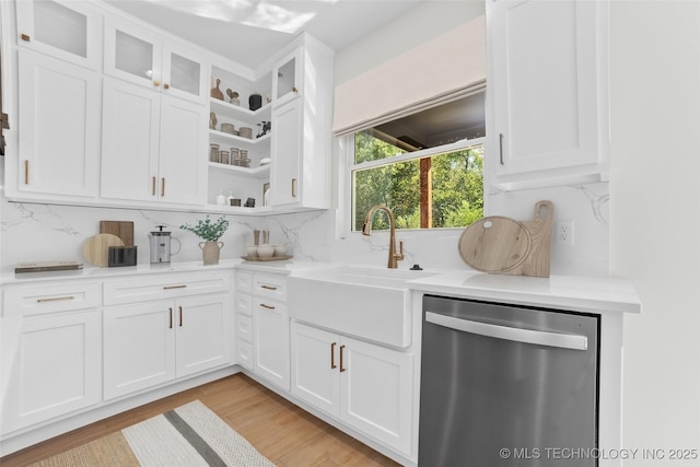 kitchen featuring white cabinetry, dishwasher, sink, and tasteful backsplash