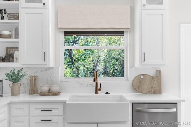 kitchen featuring sink, stainless steel dishwasher, white cabinets, and backsplash