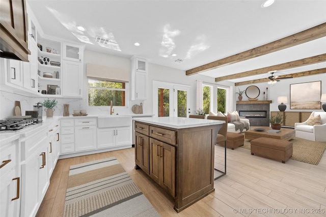 kitchen featuring a wealth of natural light, sink, a kitchen island, and white cabinets