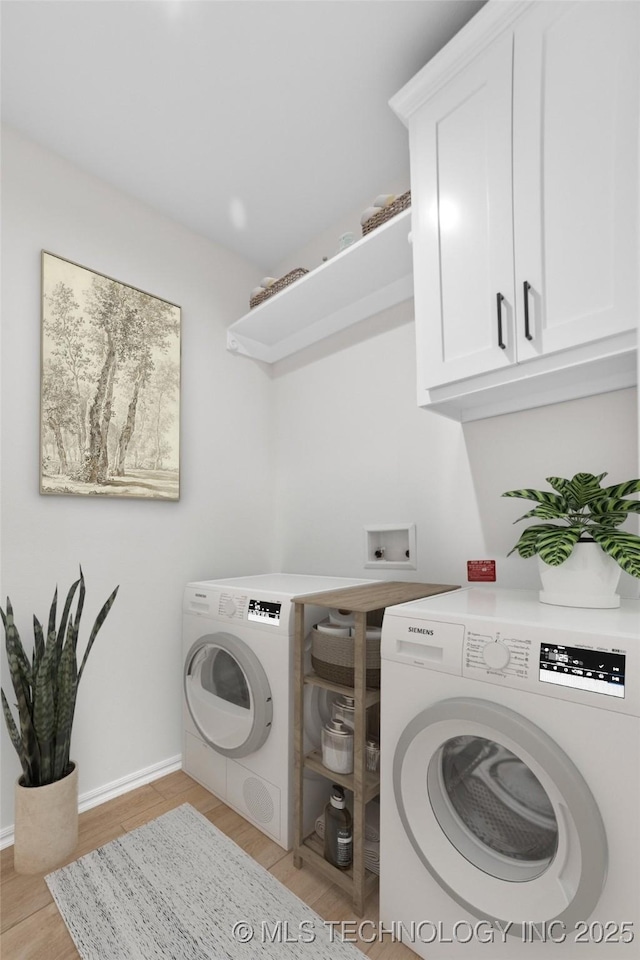 laundry room featuring cabinets, separate washer and dryer, and light wood-type flooring