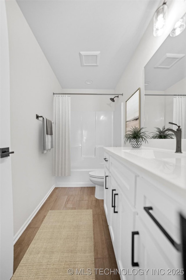 full bathroom with shower / tub combo with curtain, vanity, toilet, and hardwood / wood-style floors