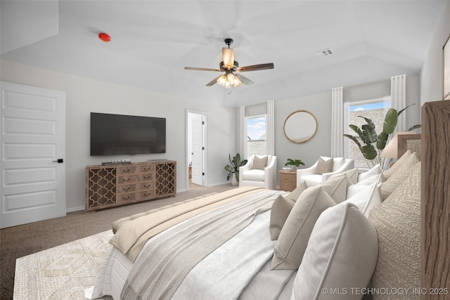 carpeted bedroom with ceiling fan, vaulted ceiling, and multiple windows