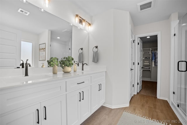 bathroom featuring vanity, a shower with door, and hardwood / wood-style floors