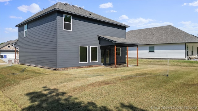 rear view of property featuring a lawn