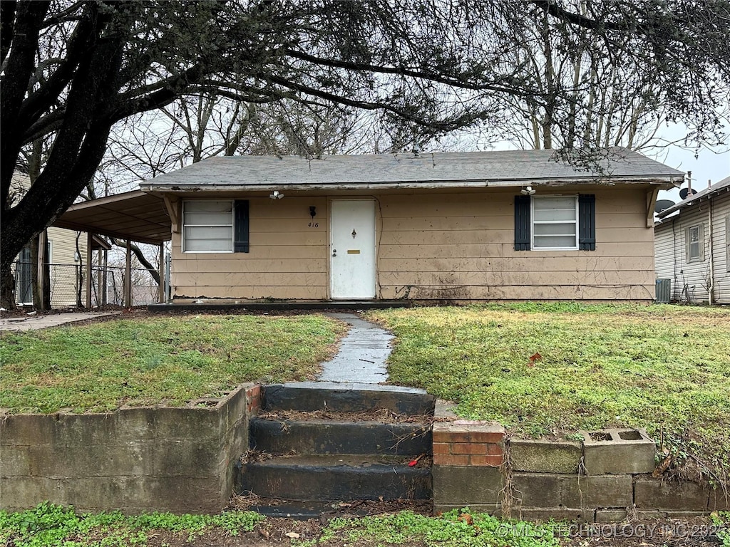 view of front facade featuring a front yard and central AC unit