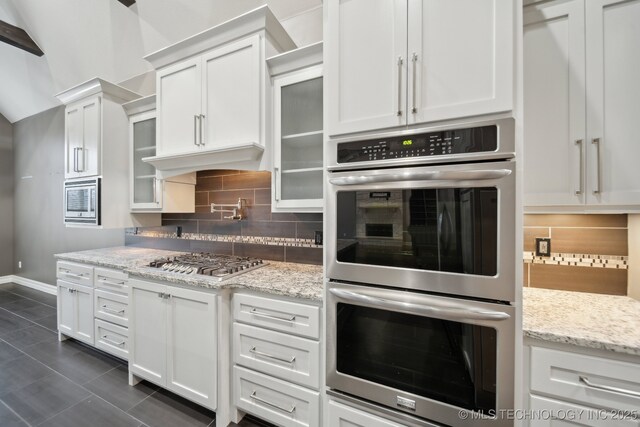 kitchen with white cabinetry, sink, and built in appliances