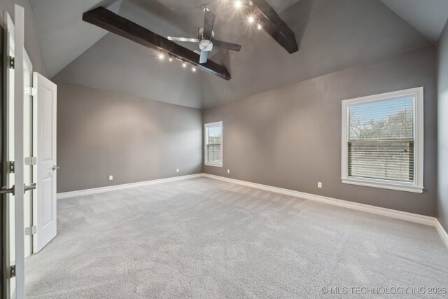 empty room with ceiling fan, light colored carpet, and vaulted ceiling with beams