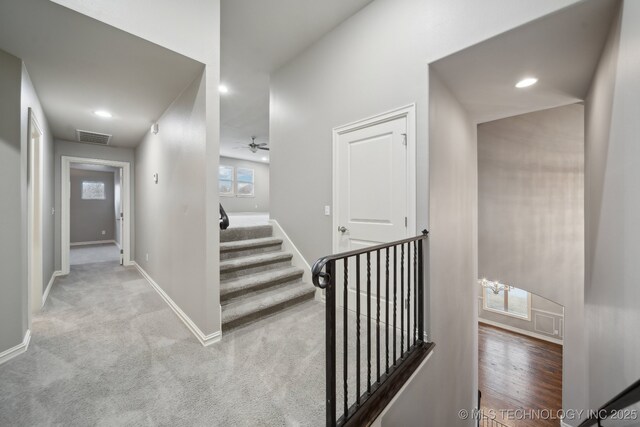 unfurnished room with light colored carpet and ceiling fan