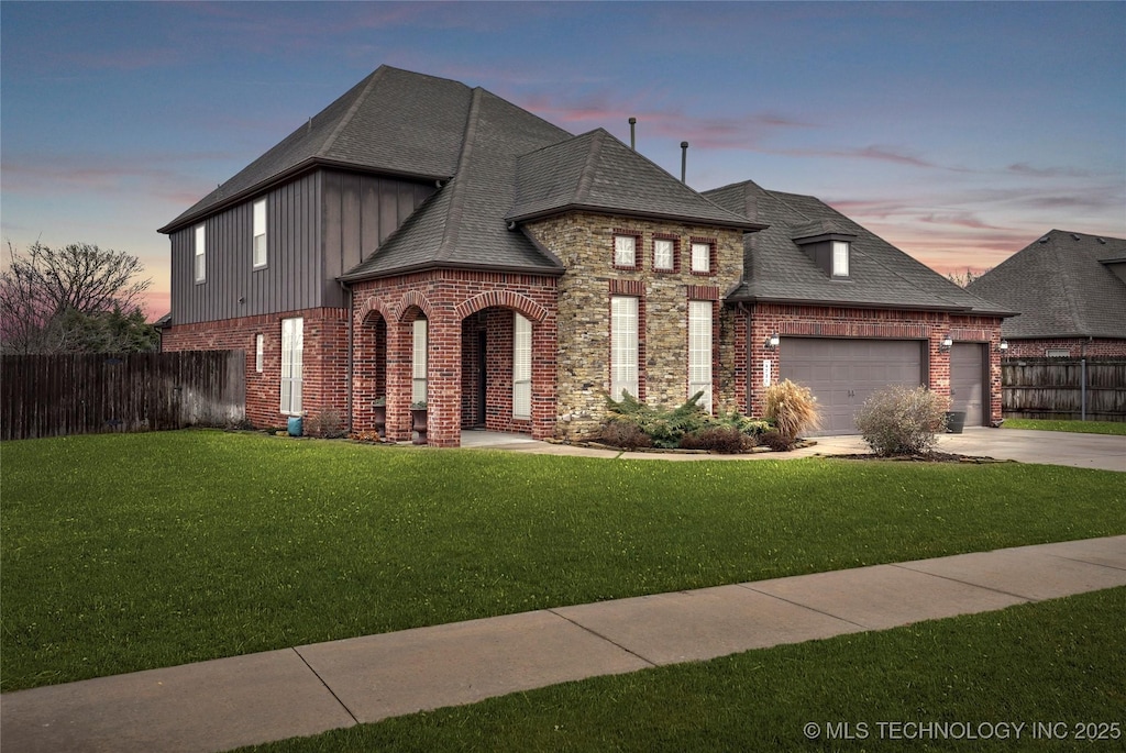 view of front of home with a garage and a lawn