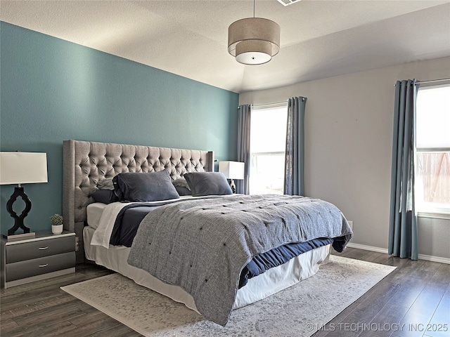 bedroom with vaulted ceiling and dark hardwood / wood-style flooring