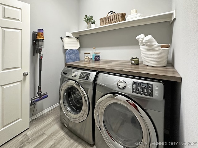 laundry area with independent washer and dryer and light wood-type flooring