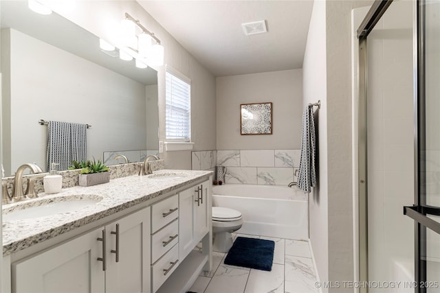 bathroom with a washtub, vanity, and toilet