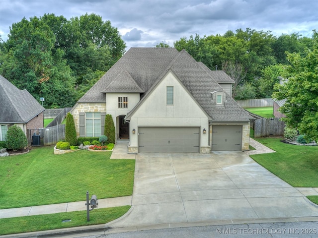 view of front facade featuring a garage, central AC, and a front yard