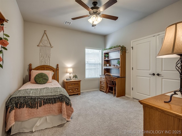 bedroom with ceiling fan, light colored carpet, and a closet