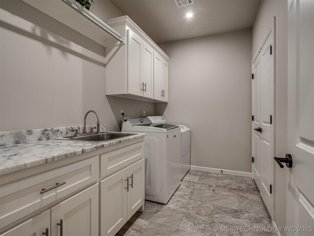 laundry room with cabinets, washer and clothes dryer, and sink