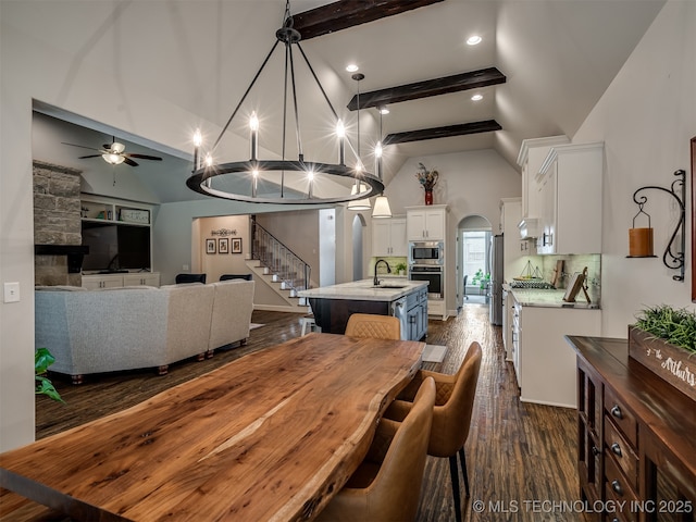 dining area with dark hardwood / wood-style floors, high vaulted ceiling, sink, ceiling fan, and beam ceiling