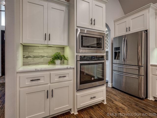 kitchen with white cabinetry, decorative backsplash, dark hardwood / wood-style flooring, and appliances with stainless steel finishes