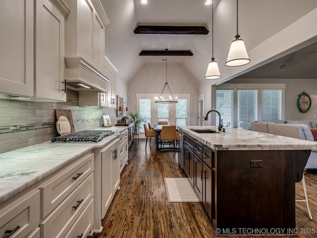 kitchen featuring sink, white cabinets, and decorative light fixtures