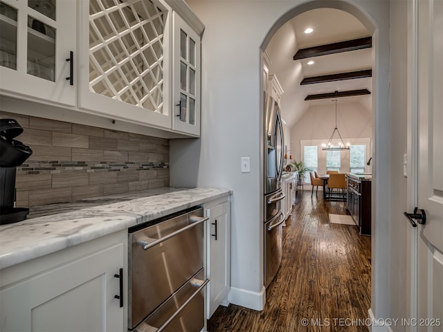 bar featuring tasteful backsplash, a chandelier, appliances with stainless steel finishes, dark hardwood / wood-style floors, and white cabinets