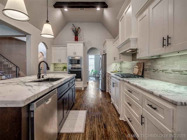 kitchen featuring stainless steel appliances, white cabinetry, hanging light fixtures, and sink