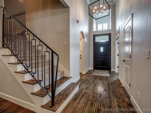 foyer with dark hardwood / wood-style flooring and a towering ceiling