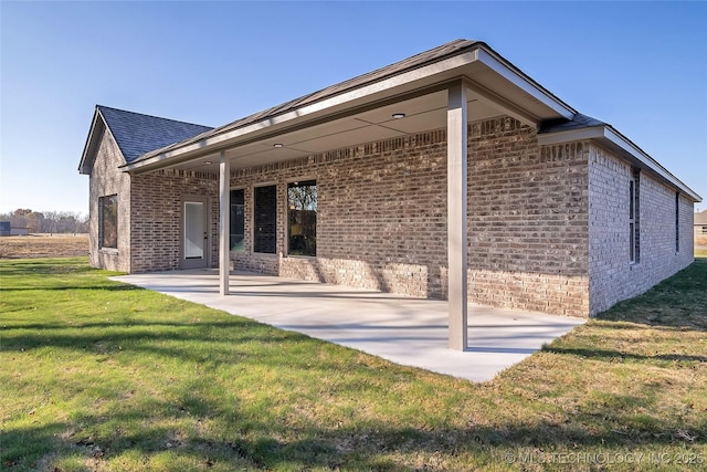 rear view of property featuring a yard and a patio area