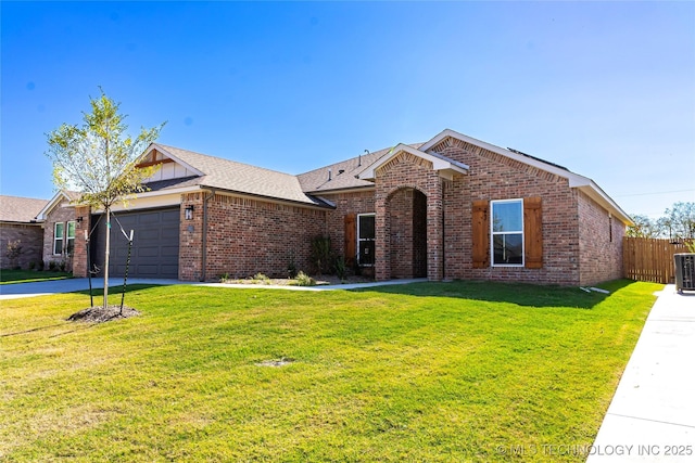 ranch-style house featuring a garage, central AC unit, and a front lawn