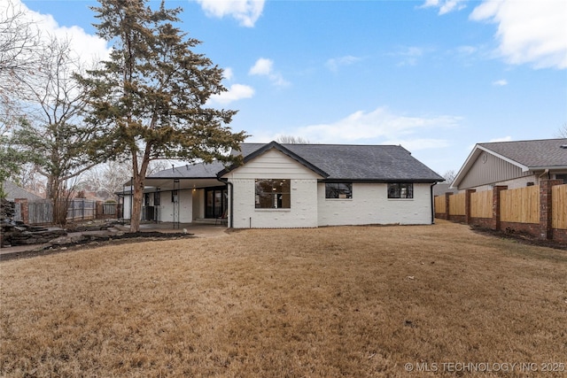 rear view of property featuring a lawn