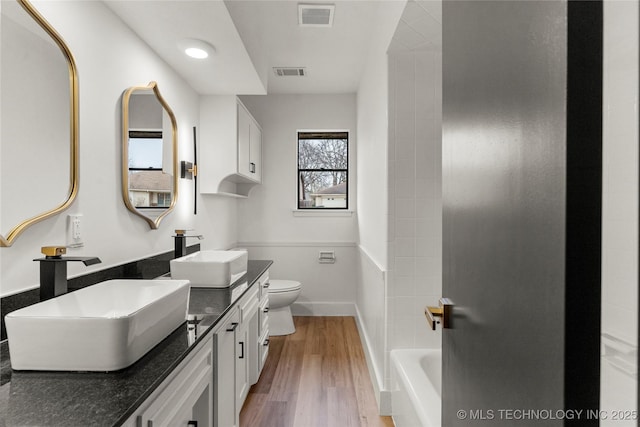 bathroom featuring vanity, hardwood / wood-style floors, and toilet