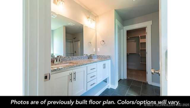 bathroom with an enclosed shower, vanity, and tile patterned floors