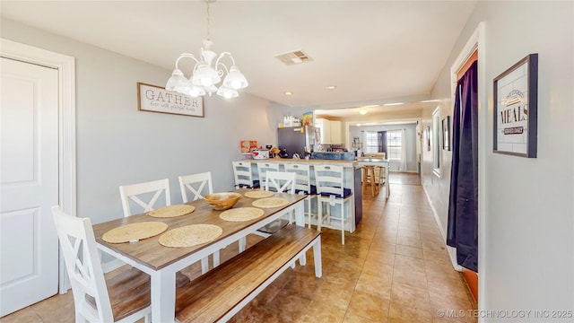 tiled dining room featuring a chandelier