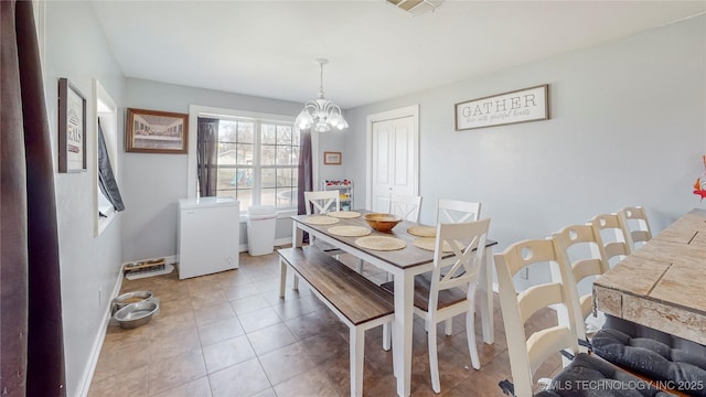 tiled dining space featuring a chandelier