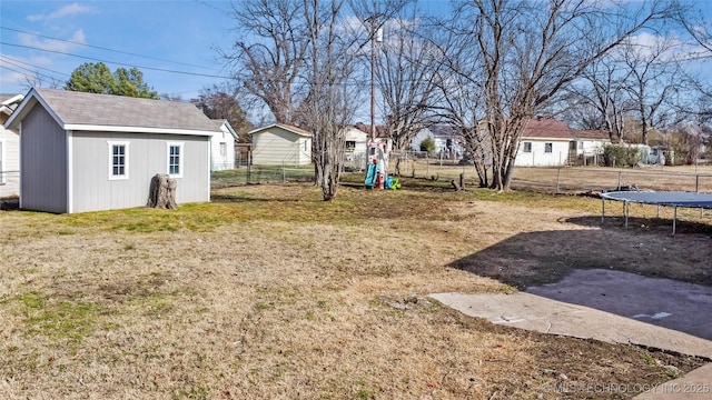 view of yard with an outdoor structure, a playground, and a trampoline