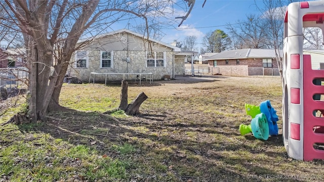 view of yard with a playground and a trampoline