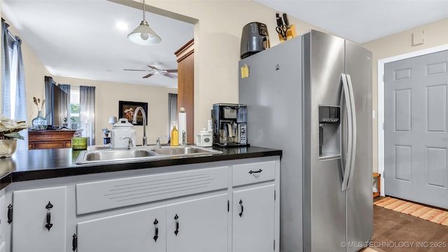 kitchen featuring stainless steel refrigerator with ice dispenser, decorative light fixtures, sink, and white cabinets