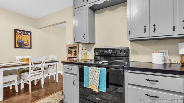 kitchen featuring black / electric stove, dark hardwood / wood-style flooring, and gray cabinets