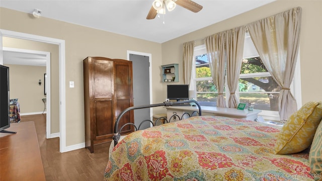 bedroom with ceiling fan and dark hardwood / wood-style flooring