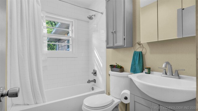 full bathroom featuring vanity, shower / bath combination with curtain, and toilet