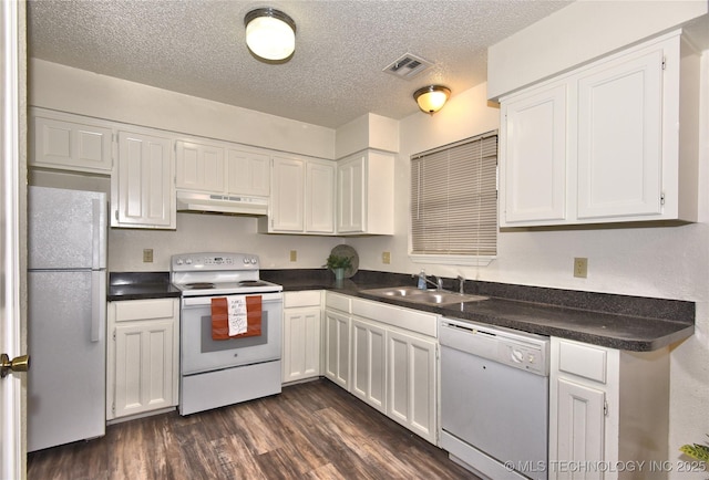 kitchen with dark hardwood / wood-style floors, white cabinetry, sink, and white appliances