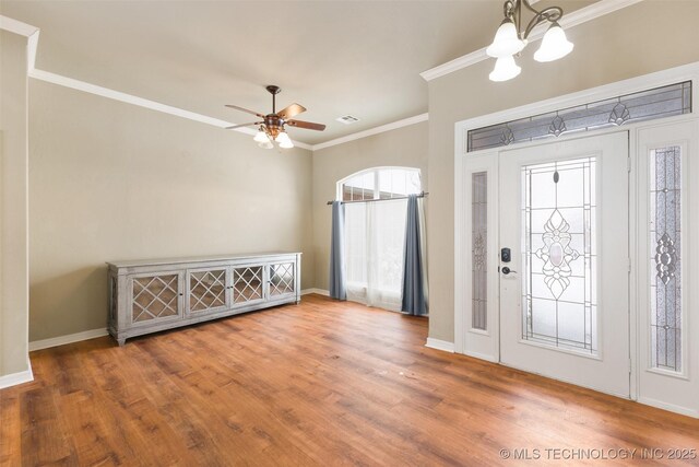 foyer featuring ceiling fan with notable chandelier, ornamental molding, and hardwood / wood-style floors