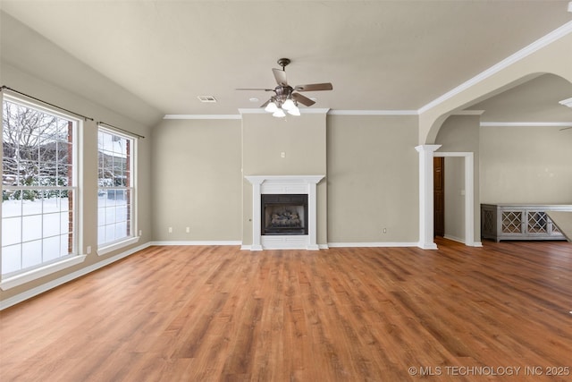 unfurnished living room with hardwood / wood-style flooring, ornamental molding, ceiling fan, and ornate columns