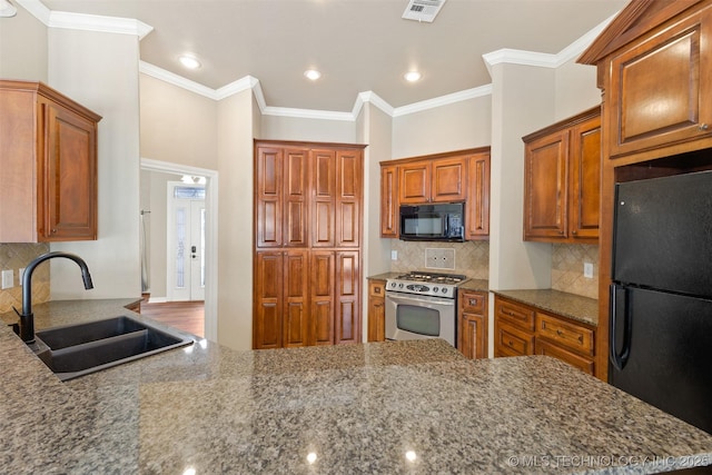 kitchen featuring stone countertops, sink, ornamental molding, and black appliances