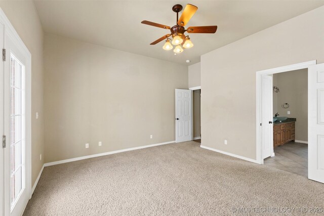 unfurnished bedroom with light carpet, ceiling fan, and ensuite bathroom