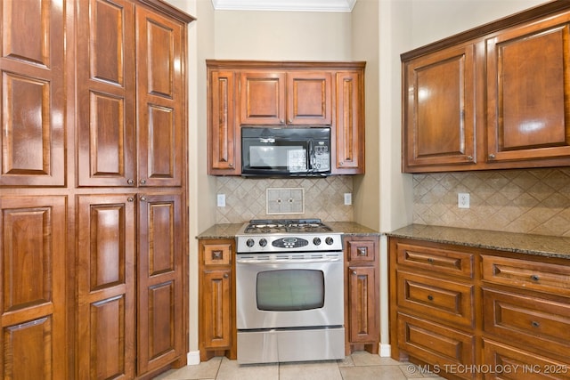 kitchen featuring light stone counters, light tile patterned floors, decorative backsplash, and gas stove