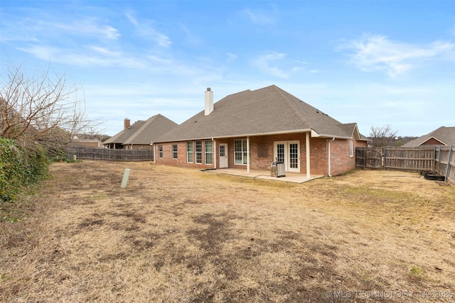 rear view of house featuring a patio area and a lawn